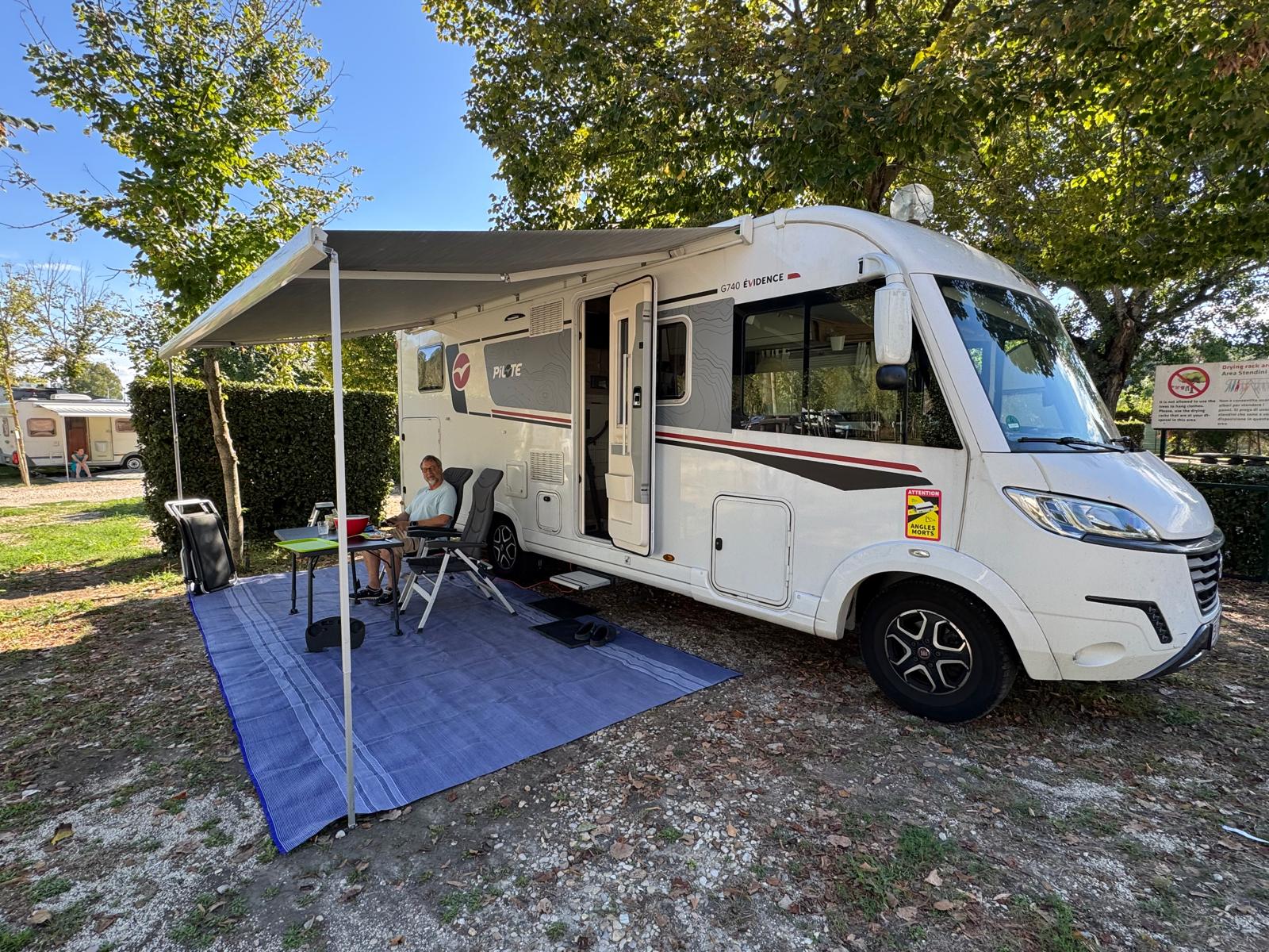 Rom mit dem Wohnmobil – zwei Tage Ewigkeit zwischen Engelsburg und Petersplatz Lilibet mit ausgefahrener Markise und Sitzplatz unter Bäumen im Flaminio Village